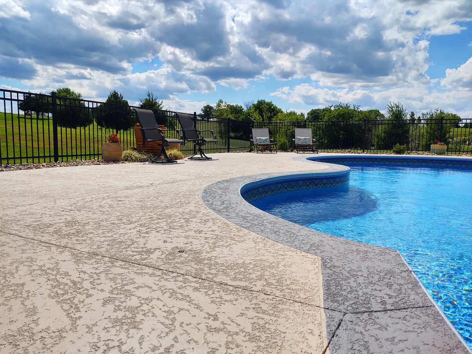Professional concrete pool deck installation by Edmond Concrete Pros in Edmond OK showing finished pool decking